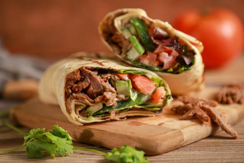 Two cut kebab wraps filled with meat and fresh salad